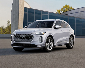 Head-on view of a silver Audi Q5 parked at an ultra-modern building. Search inventory.