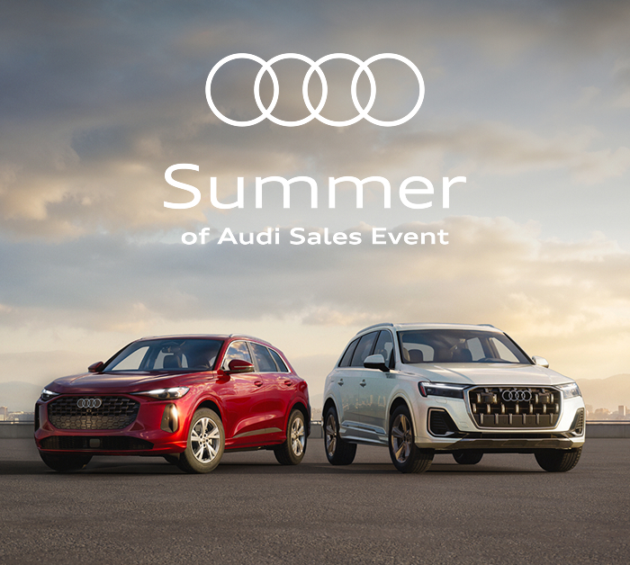 Head-on view of a red Audi Q5 and white Audi Q7 before a vanilla sky. Summer of Audi Sales Event. Find yours.